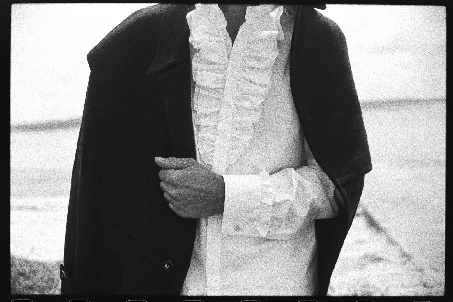 Photo prise de face, close up sur les détails des volants de la chemise ainsi que sur les poignets. On ne voit pas la tête du mannequin.