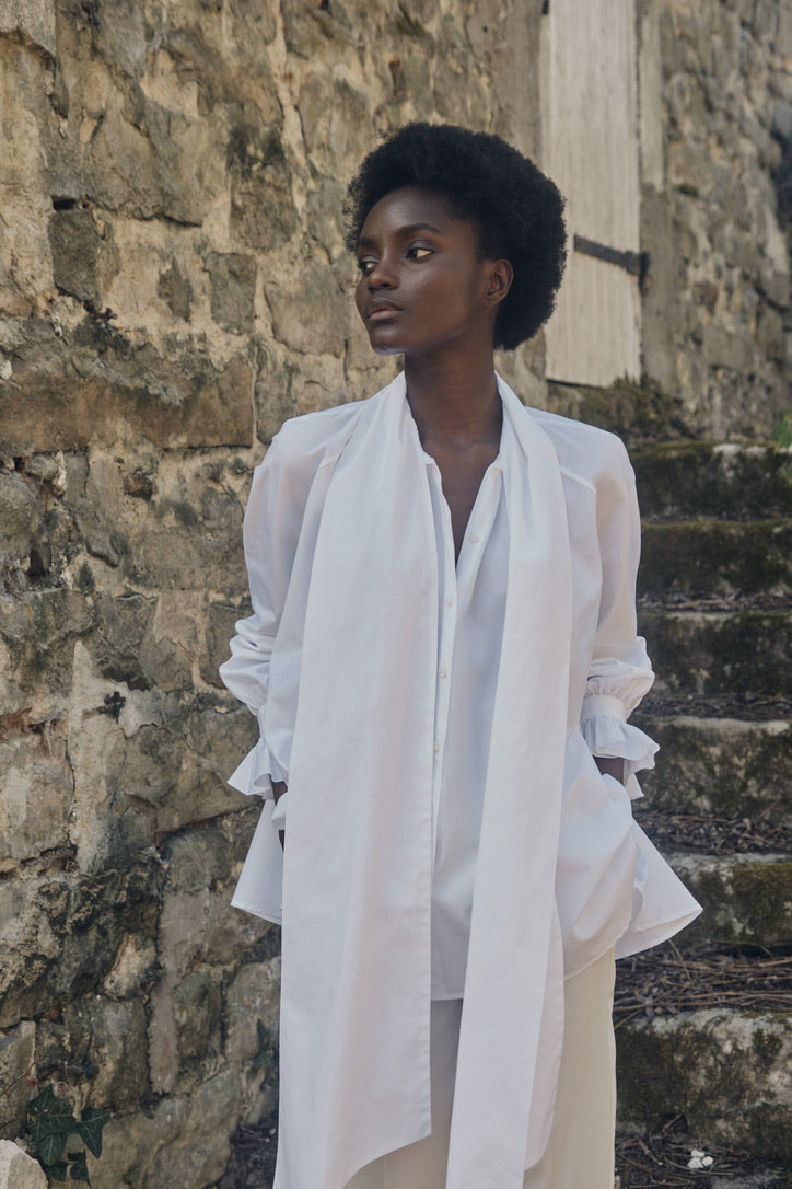 Mannequin portant la chemise Céleste, le col lavallière ouvert et la chemise légèrement déboutonnée.