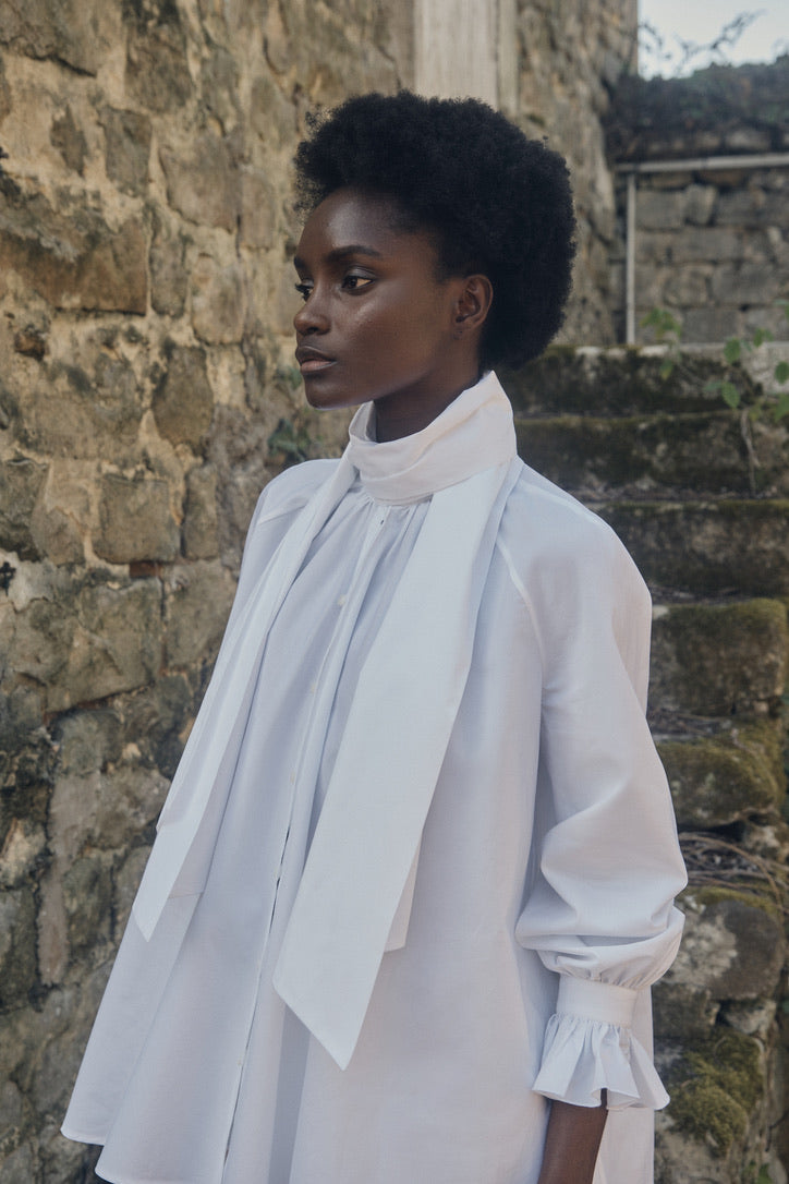 Mannequin portant la chemise Céleste, le col lavallière enroulé autour de son cou.