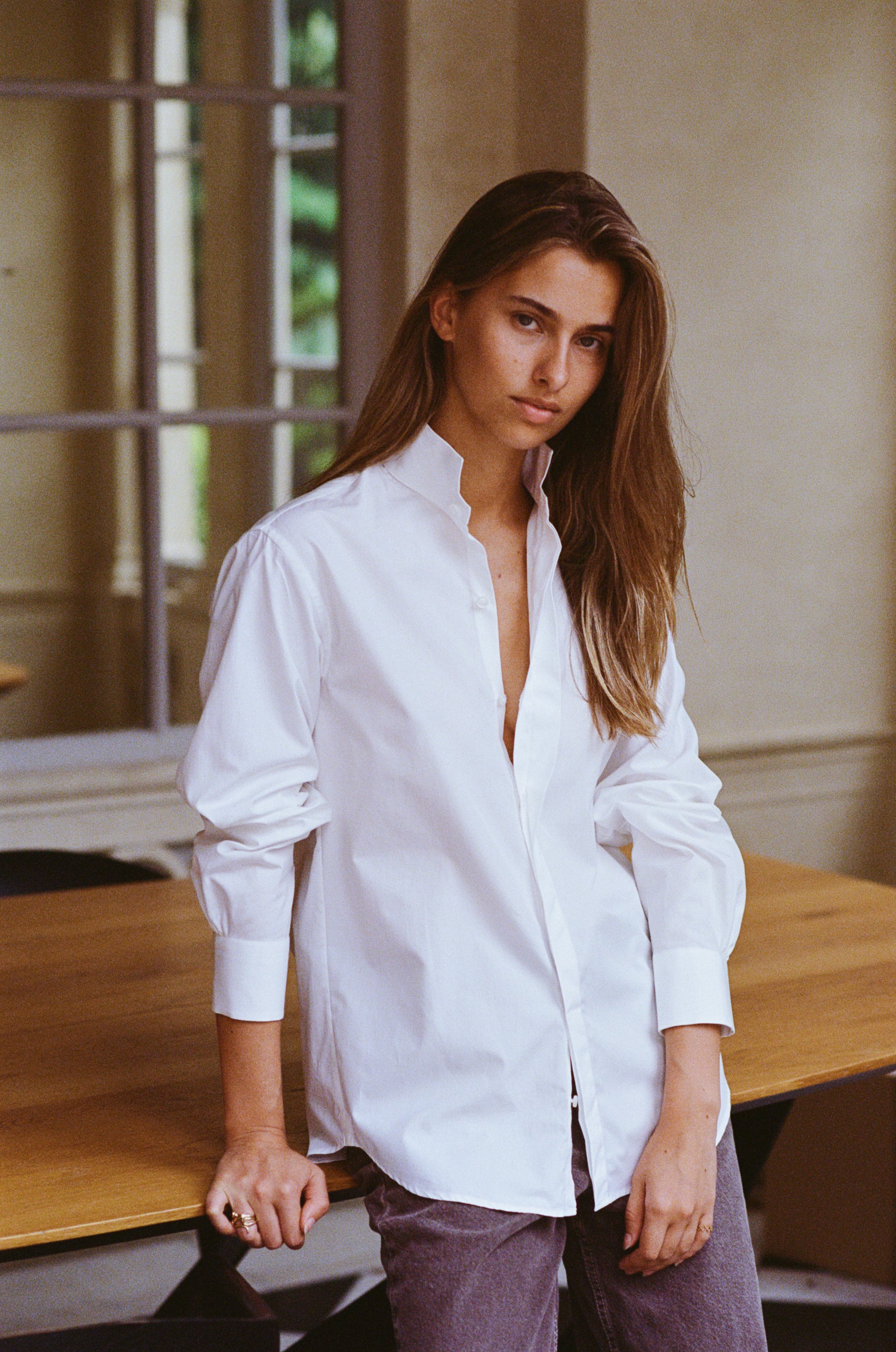 La chemise AMAZONE en blanc immaculé, pièce centrale de la collection Bourrienne, revisite élégamment le col ancien et présente des fronces distinctives à l'arrière, ajoutant une touche de raffinement.