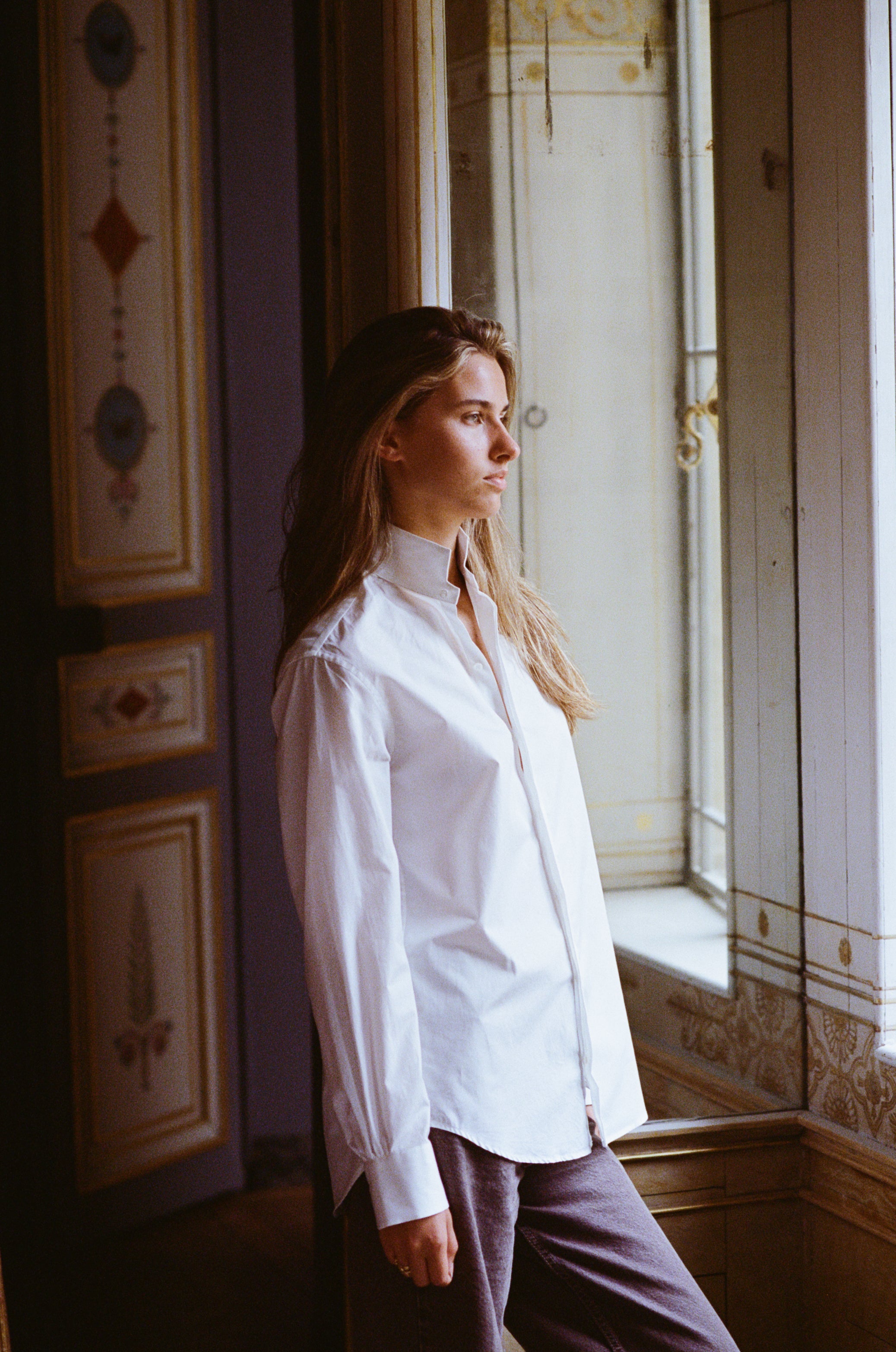 La chemise AMAZONE en blanc immaculé, pièce centrale de la collection Bourrienne, revisite élégamment le col ancien et présente des fronces distinctives à l'arrière, ajoutant une touche de raffinement.