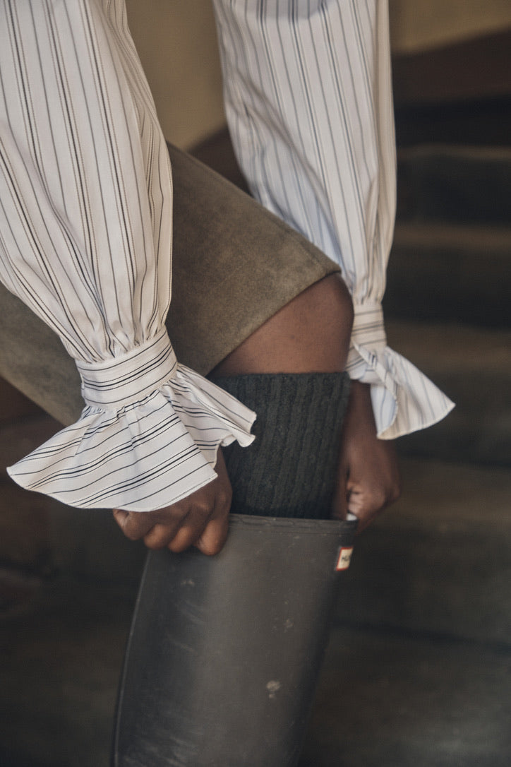 Close-up sur les poignets de la chemise BOUDOIR Rayée Kaki, et ses finitions délicates à volant.