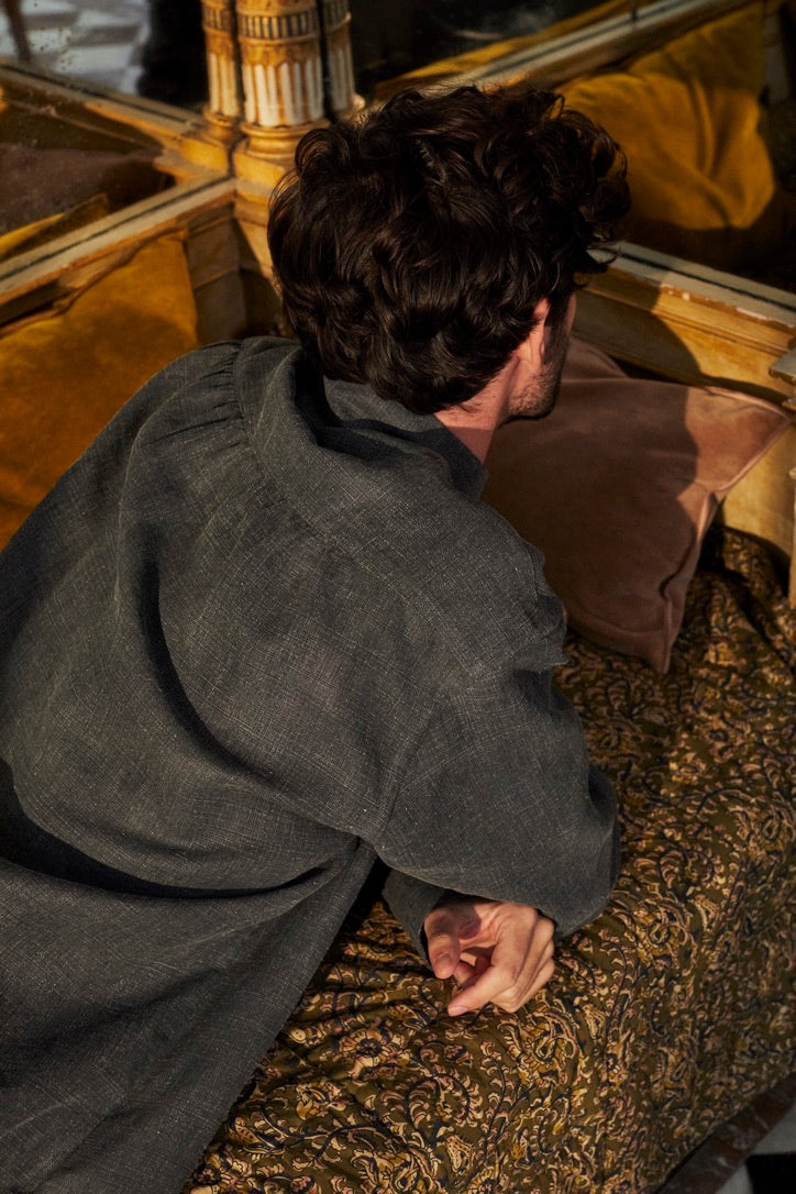 Mannequin homme allongé, de dos, portant la chemise SCULPTEUR en lin couleur gris anthracite.