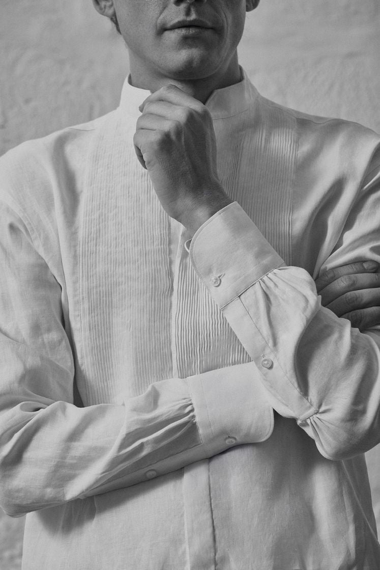 Homme portant une chemise blanche en lin avec un plastron plissé