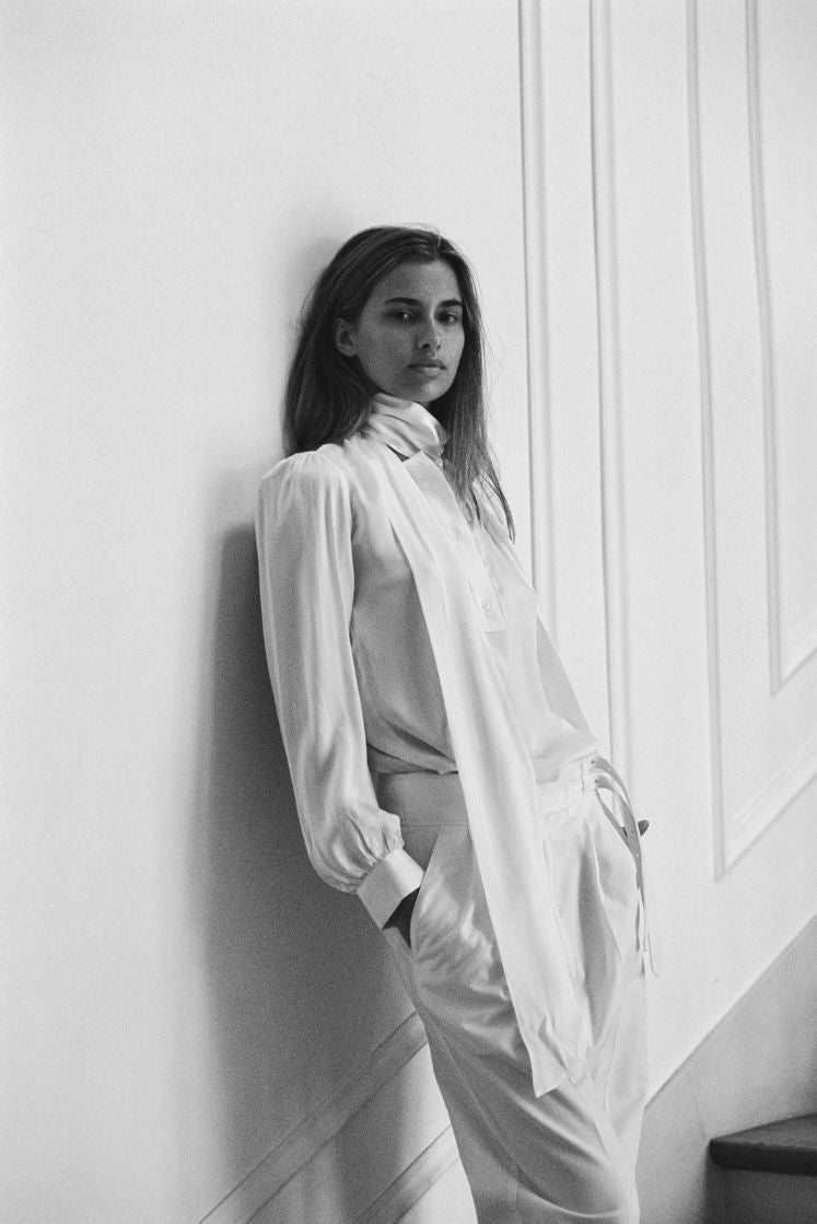 Femme portant une chemise blanche en soie avec un col lavallière