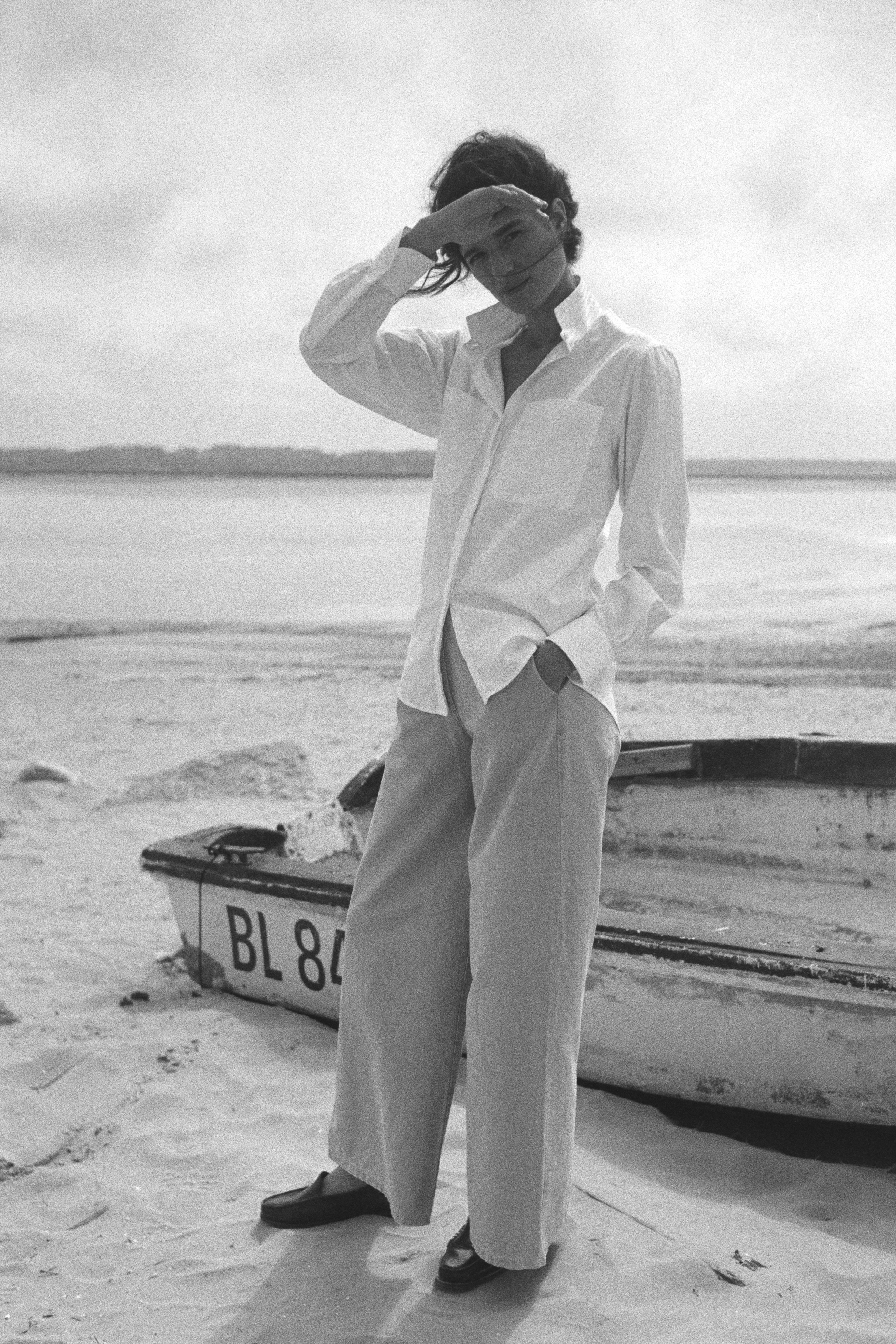 BOURRIENNE PARIS X: Photo de plein pied et de face du mannequin, la chemise en coton et à rayures blanches ton sur ton qui tombe sur les hanches.
