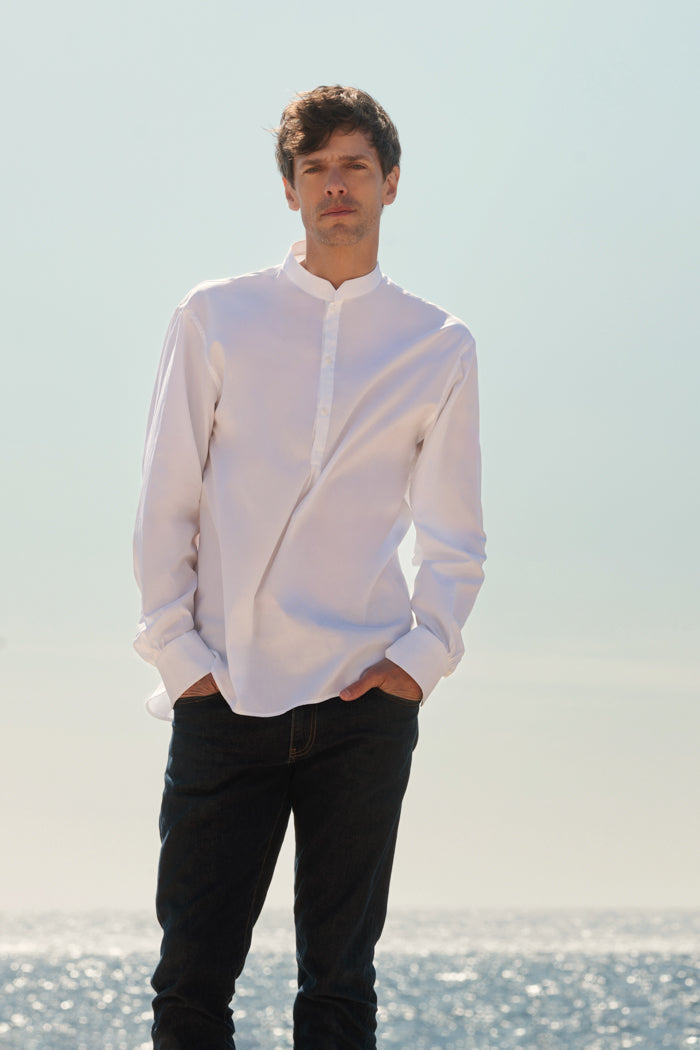Chemise blanche en popeline de coton,col officier biseauté, poignets biseautés, vue de pleins pied portée sur jean