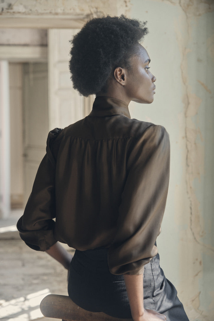 Chemise COMTESSE Soie Kaki portée par une mannequin assise de dos.