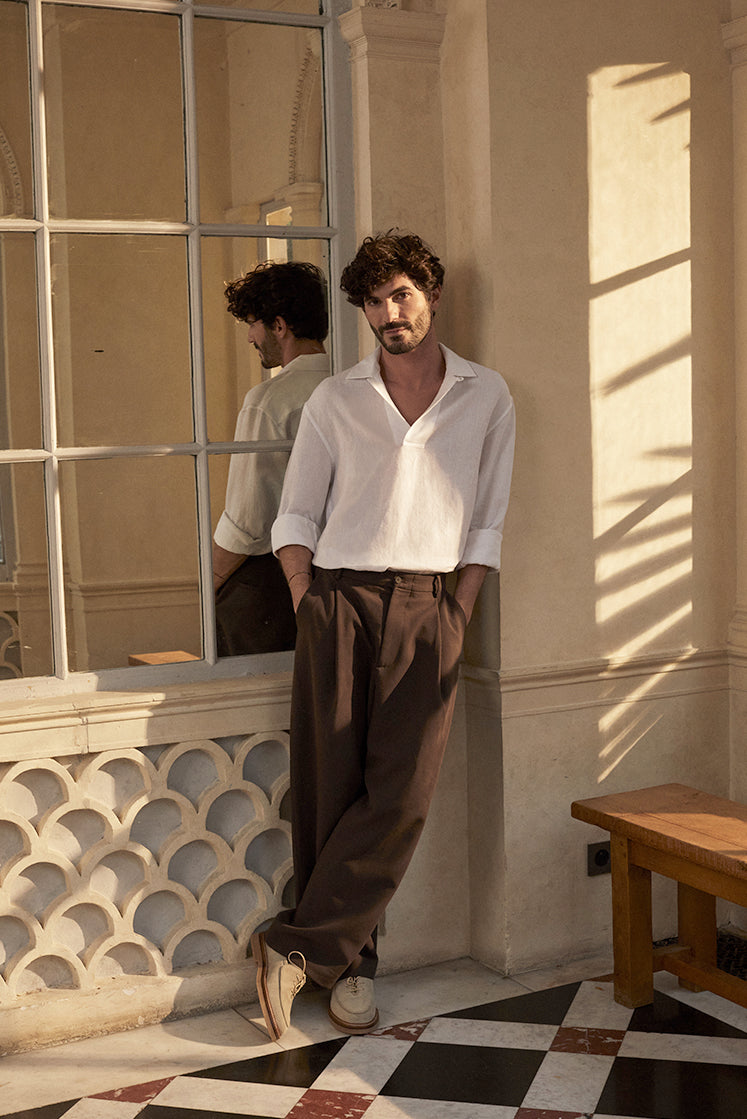 chemise Marin Lin de Bourrienne Paris X portée par un homme brun dans un intérieur ensoleillé.