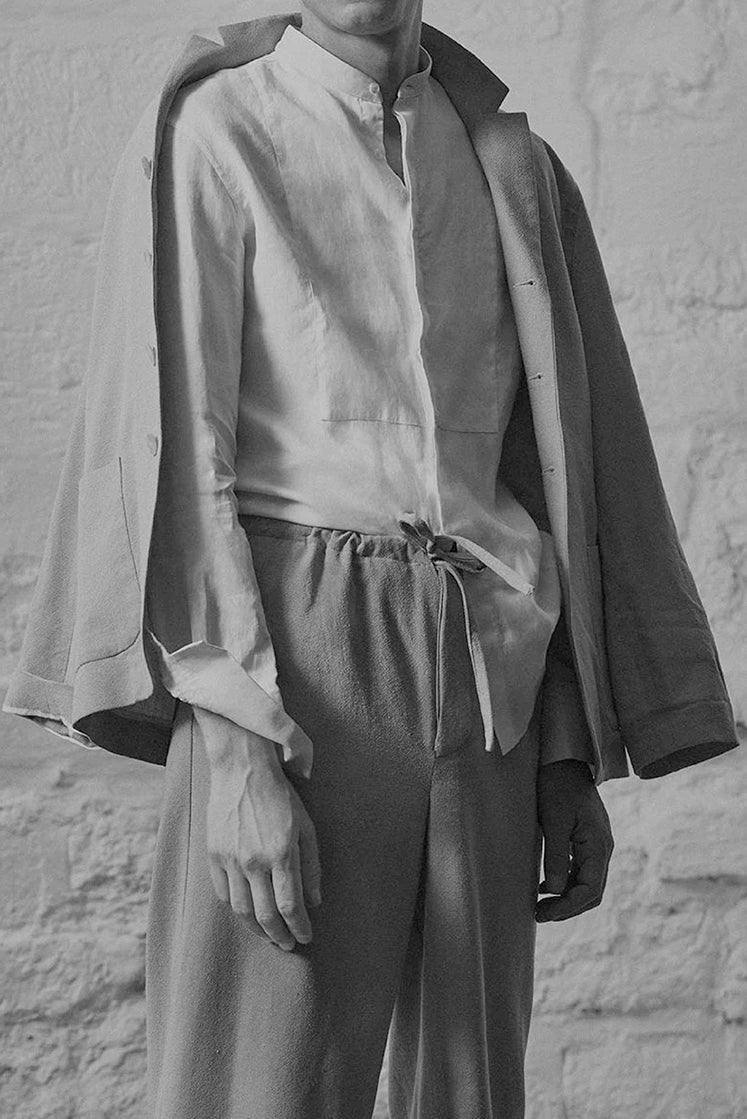 Homme portant la chemise NOCTURNE en lin avec une veste et un pantalon décontracté.