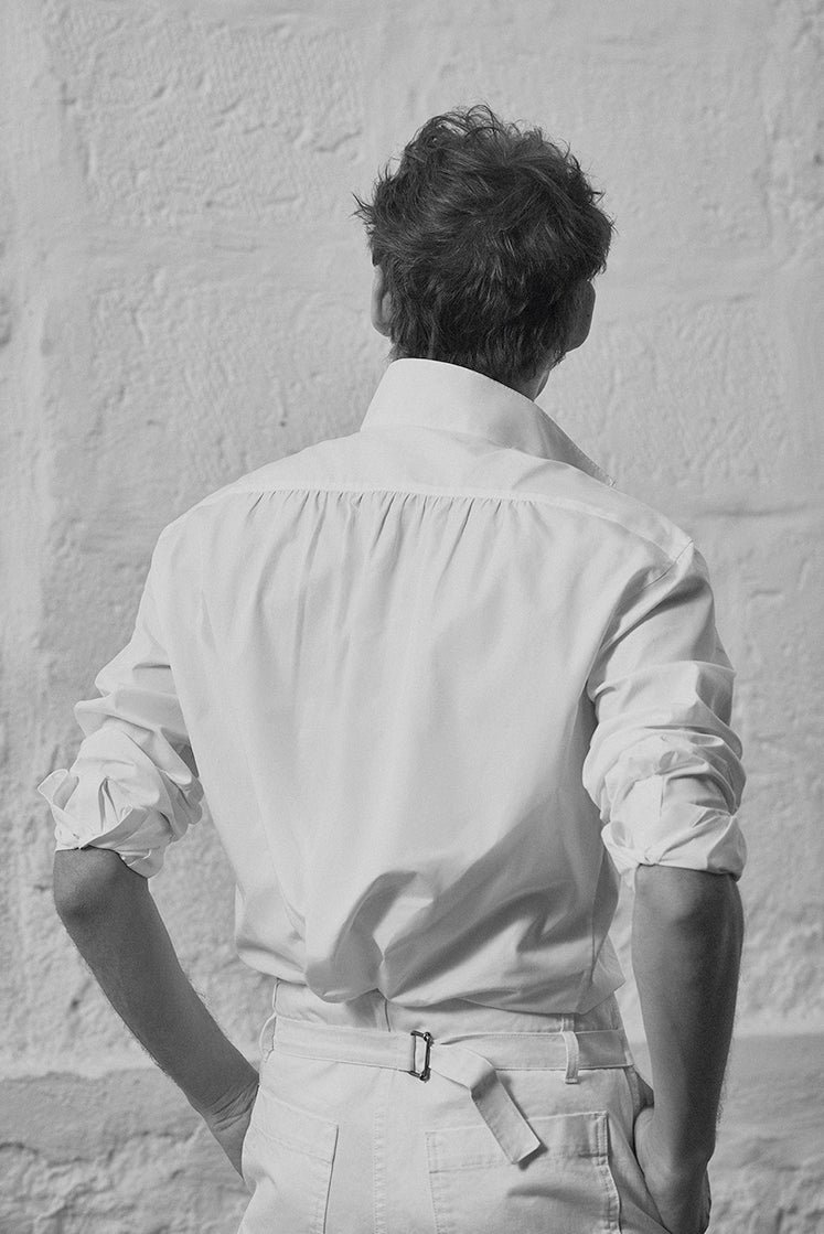 chemise blanche à col haut pour homme, avec fronces dans le dos pour l'aisance.