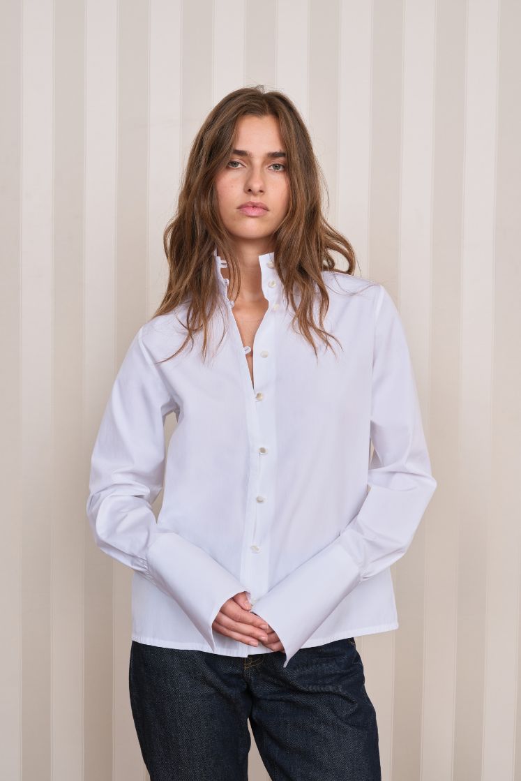 Chemise blanche femme à col haut et poignets longs.