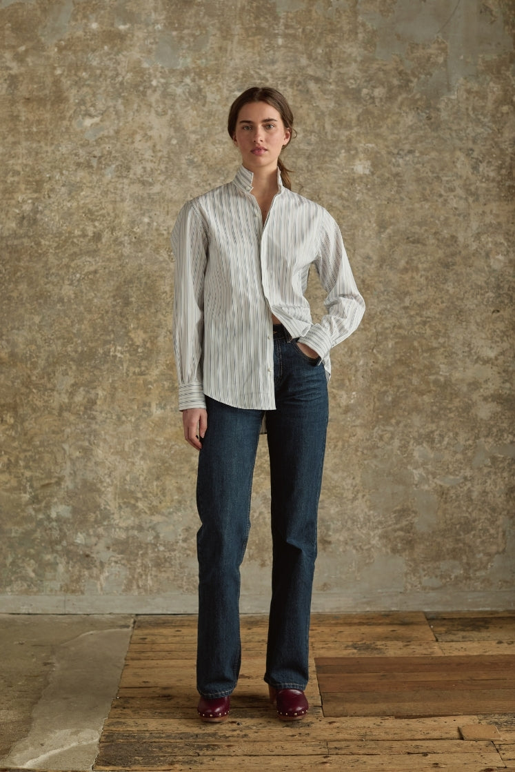 Femme portant chemise rayée blanc gris Bourrienne et jean bleu indigo, incarnant l'élégance intemporelle française, vue plein pied