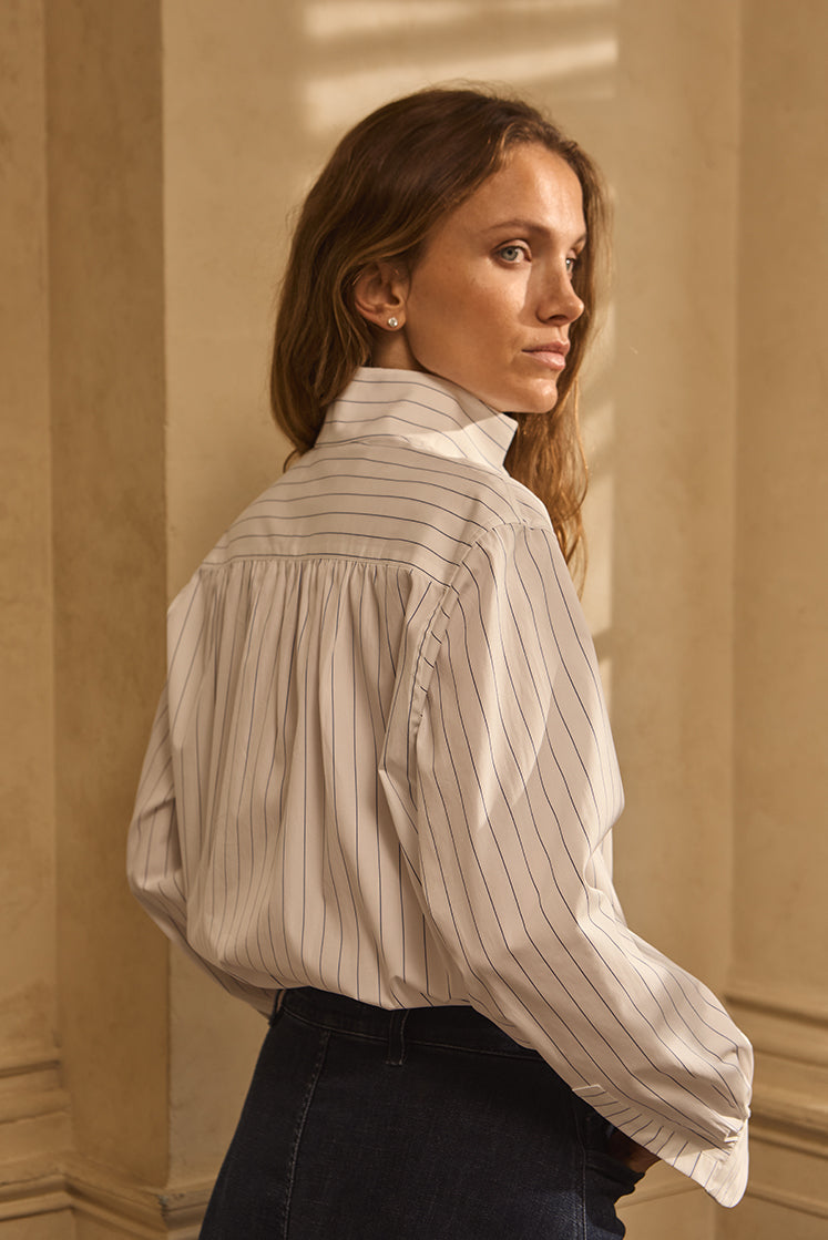 Femme de dos portant la chemise AMAZONE rayée Navy avec des fronces dans le dos.