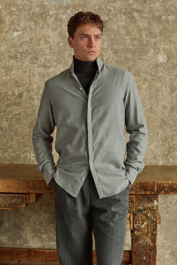 Chemise homme APPARAT en flanelle de coton grise avec col haut et poignets Bourrienne, portée sur un col roulé et associée à un pantalon gris, plan américain.