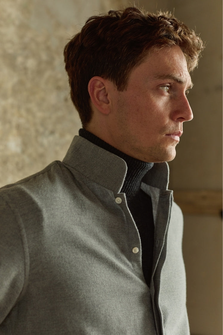 Chemise homme APPARAT en flanelle de coton grise avec col haut, légèrement déboutonnée, portée sur un col roulé, plan buste de profil.
