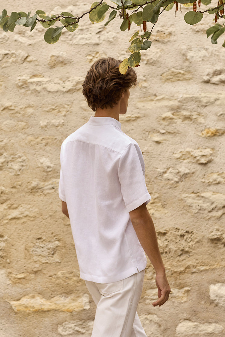 Homme portant la chemise AUBE de dos dans un jardin.