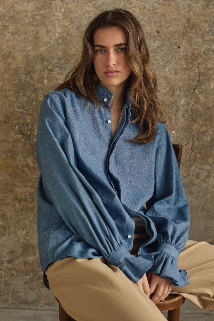 Femme portant une chemise denim bleu clair, coupe Bourrienne intemporelle, confection artisanale européenne