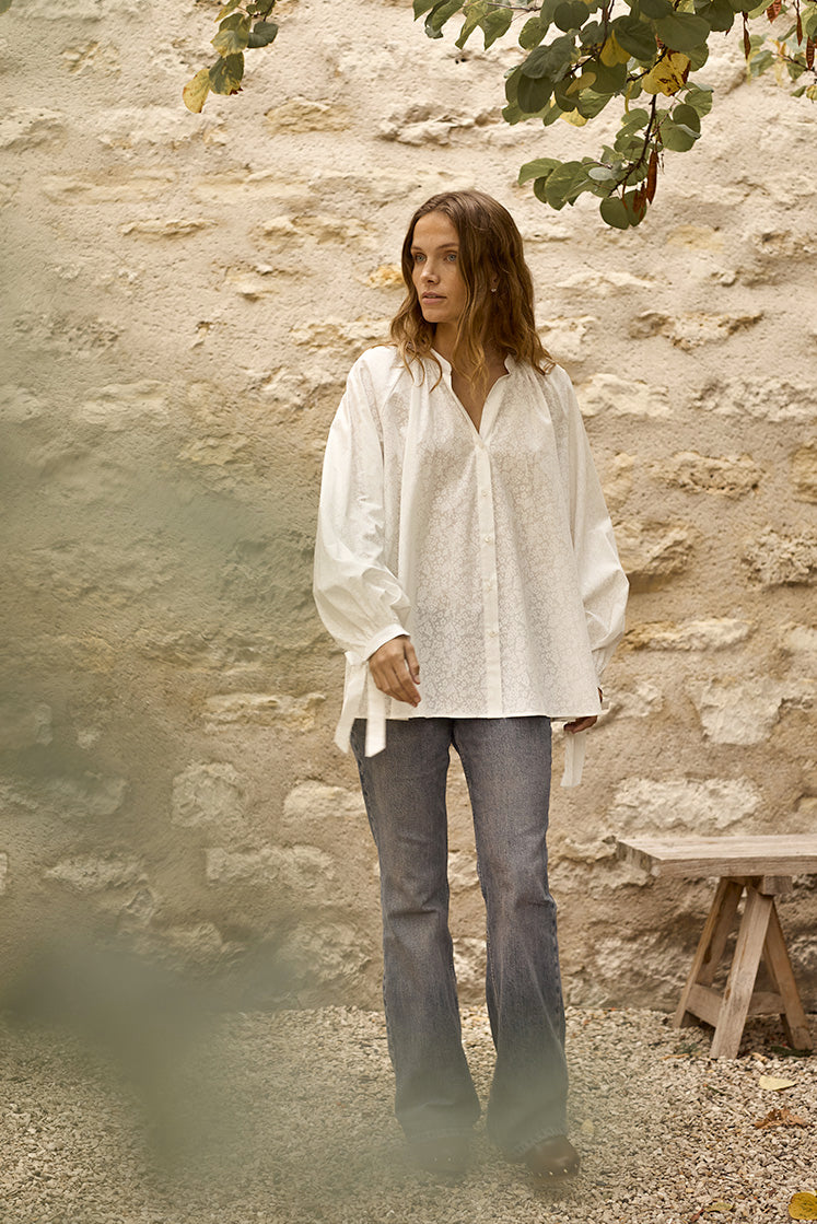 Femme marchant dans une cour portant la chemise FLIRT à motif fleuri