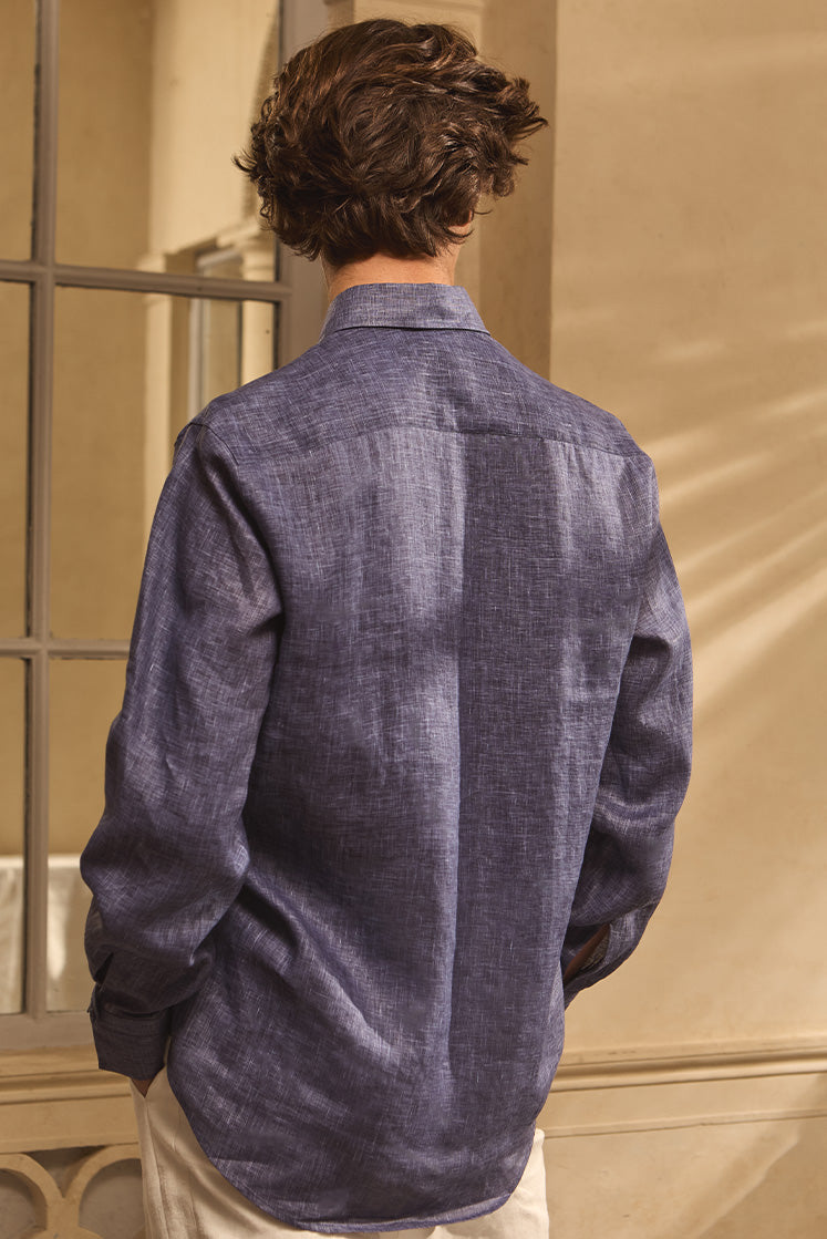Homme de dos portant une chemise en lin bleu.