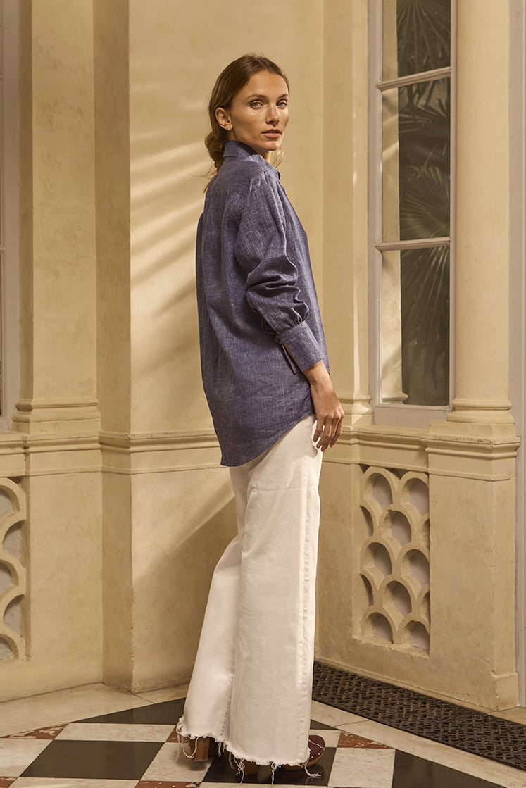 Chemise NUMÉRO VII en lin bleue vue de profil, portée sur une femme aux cheveux attachés.