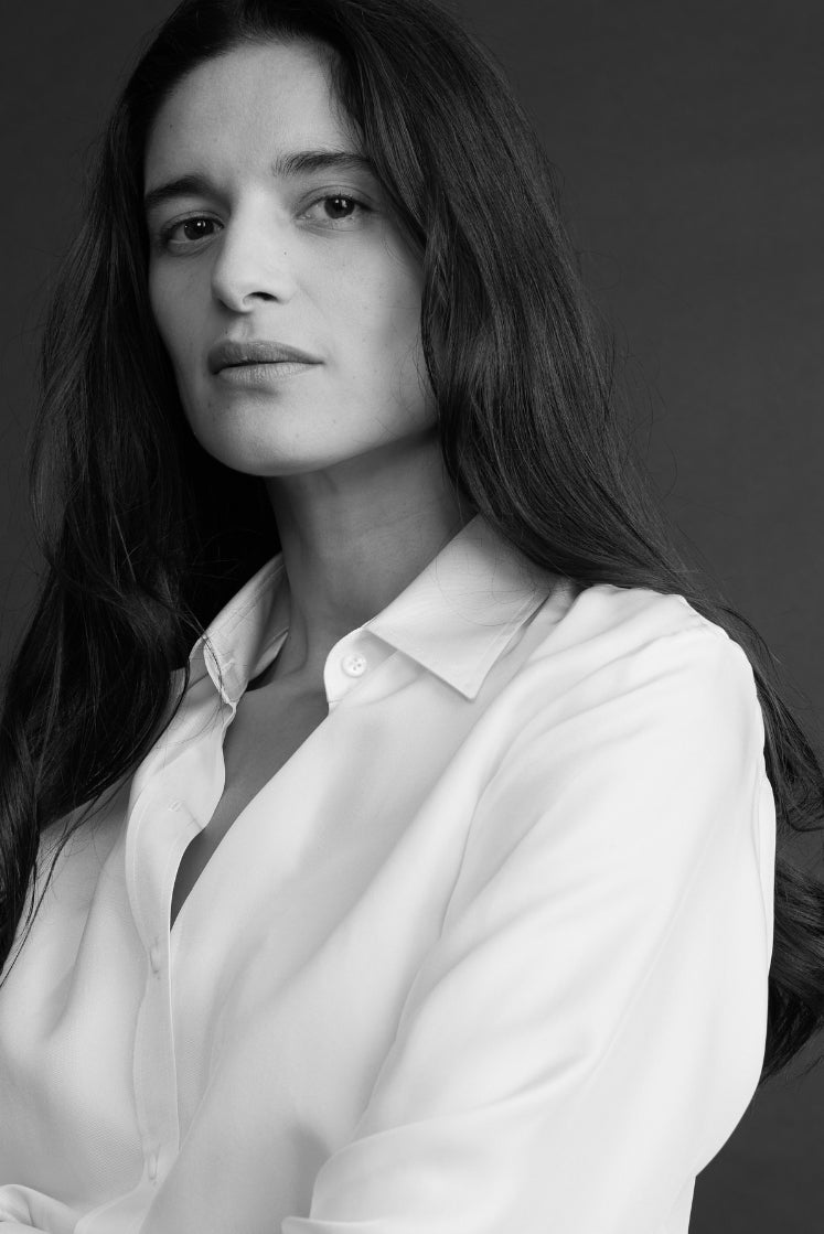 Plan buste en contre plongée d'une femme portant la chemise NUMÉRO VII en soie blanche, avec un col français.