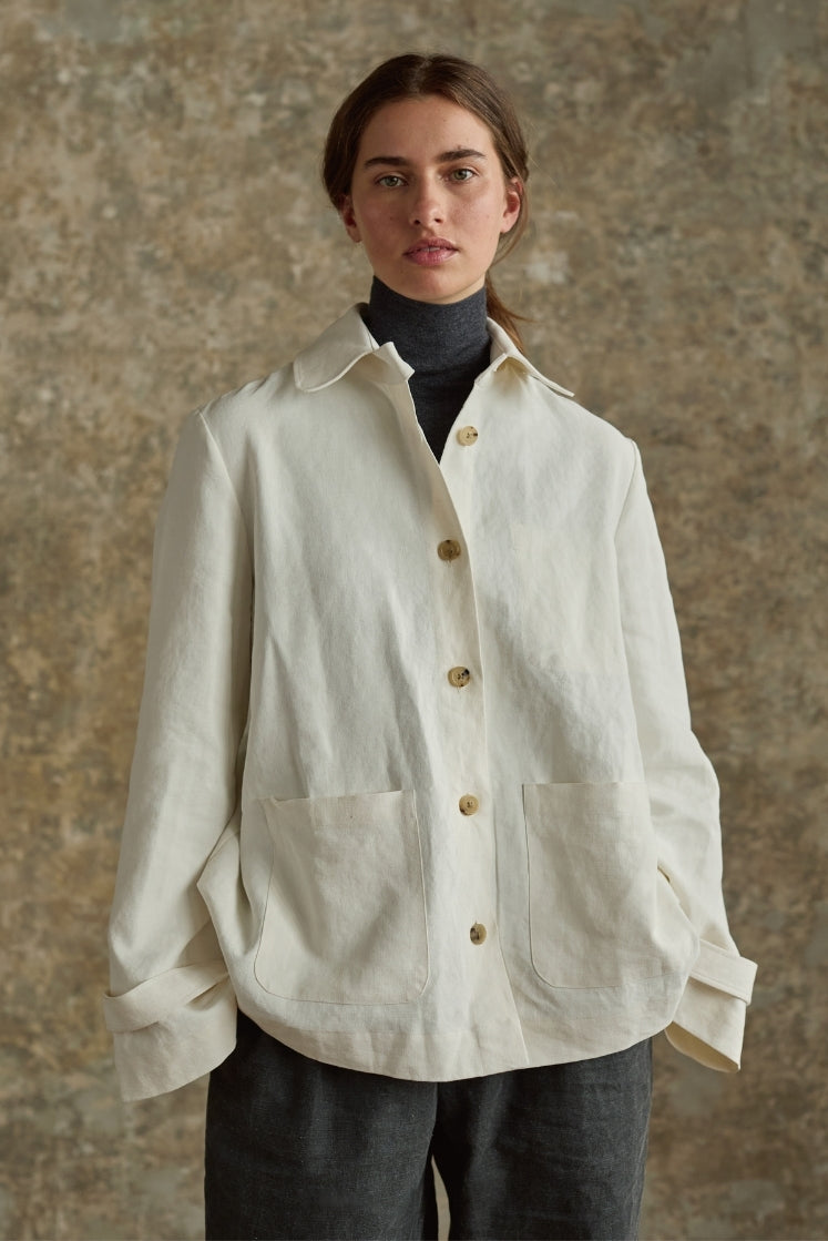 Veste blanche en lin plâtré Bourrienne Paris X portée sur un col roulé gris, poches plaquées