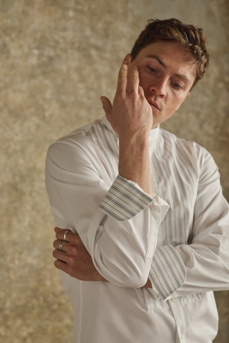 Chemise homme ROMANCIER en coton blanc avec plastron rayé bleu et gris, col officier et revers de poignets rayés.