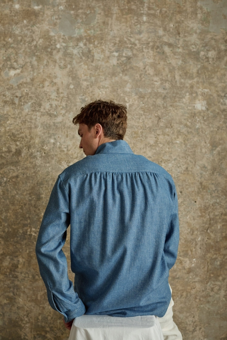Homme portant la chemise SCULPTEUR en denim bleu clair, fronces au dos, coupe Bourrienne.