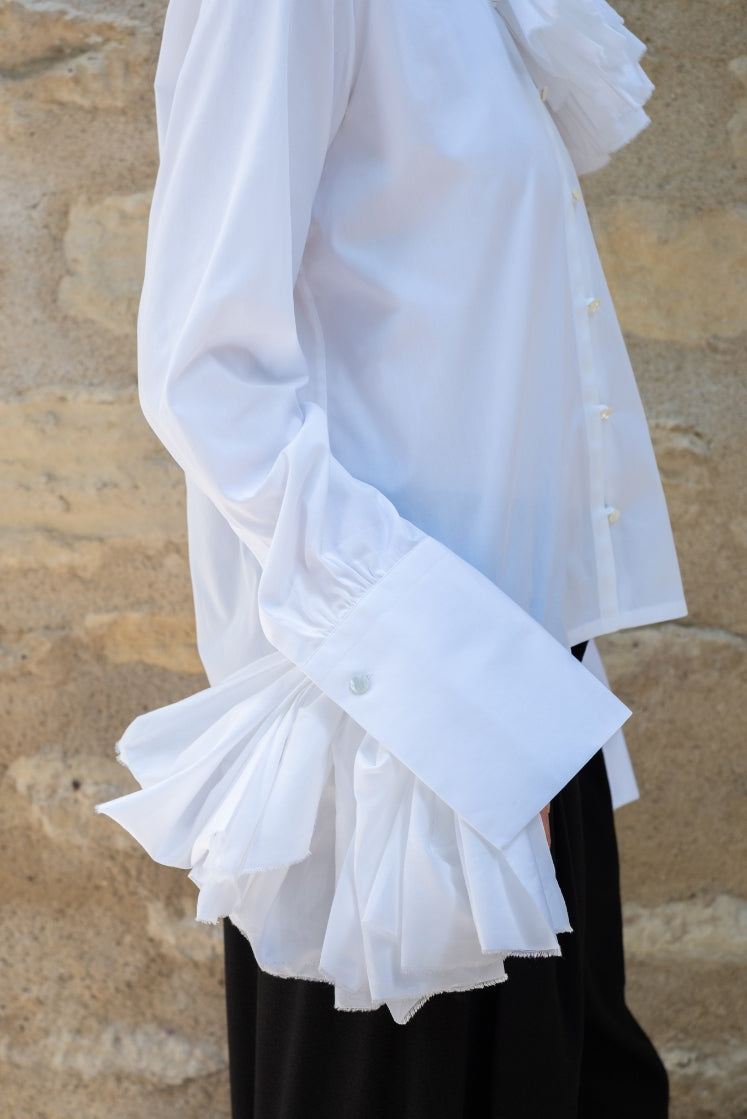 Closeup sur le poignet allongé de la chemise Juliette, avec la fleur attachée au poignet.