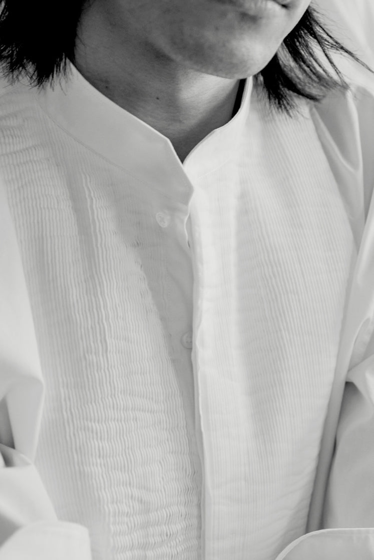 Close-up sur le plastron plissé à la main en Bretagne de la chemise COMÉDIEN en popeline de coton.