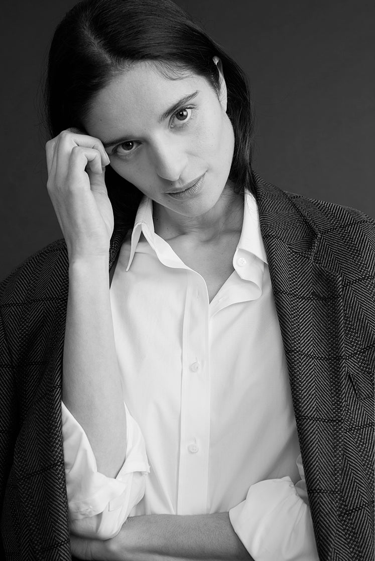 Femme portant une chemise blanche intemporelle à col français avec ne veste de blazer à carreaux.