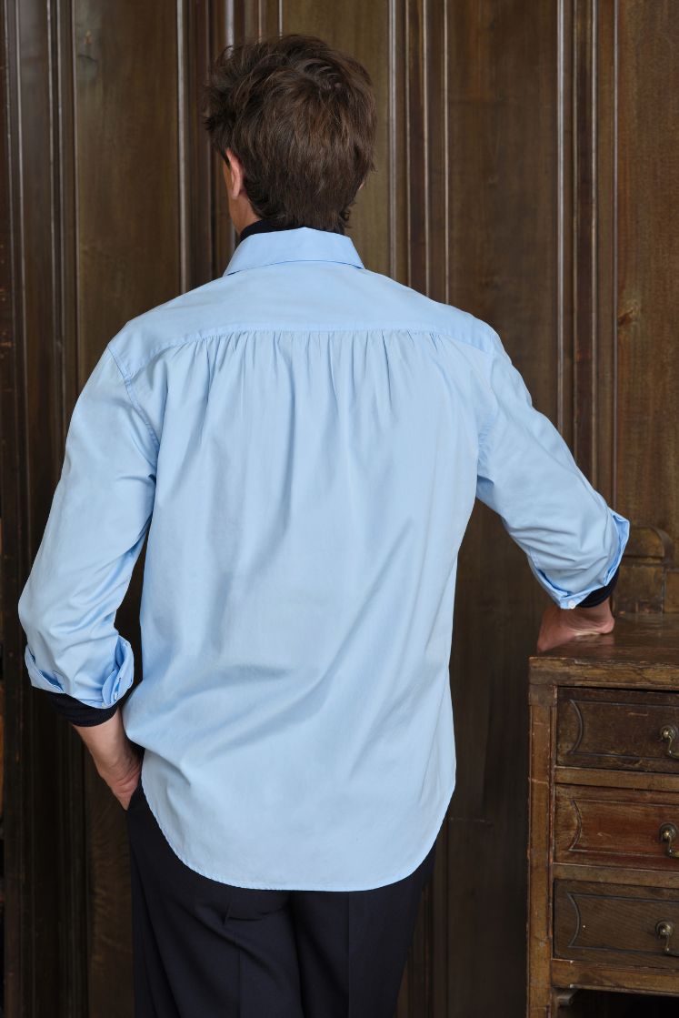 Homme de dos portant une chemise en coton bleue avec des fronces au dos, coupe Bourrienne.