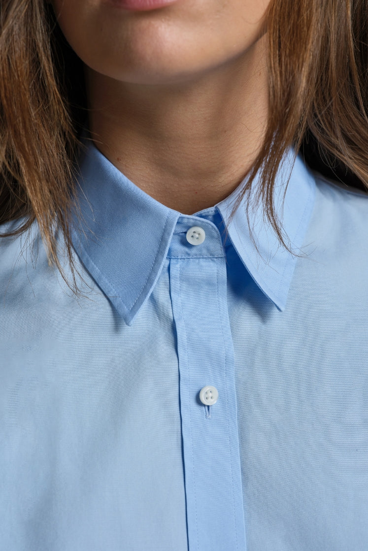 Chemise bleu ciel à col français boutonnée.