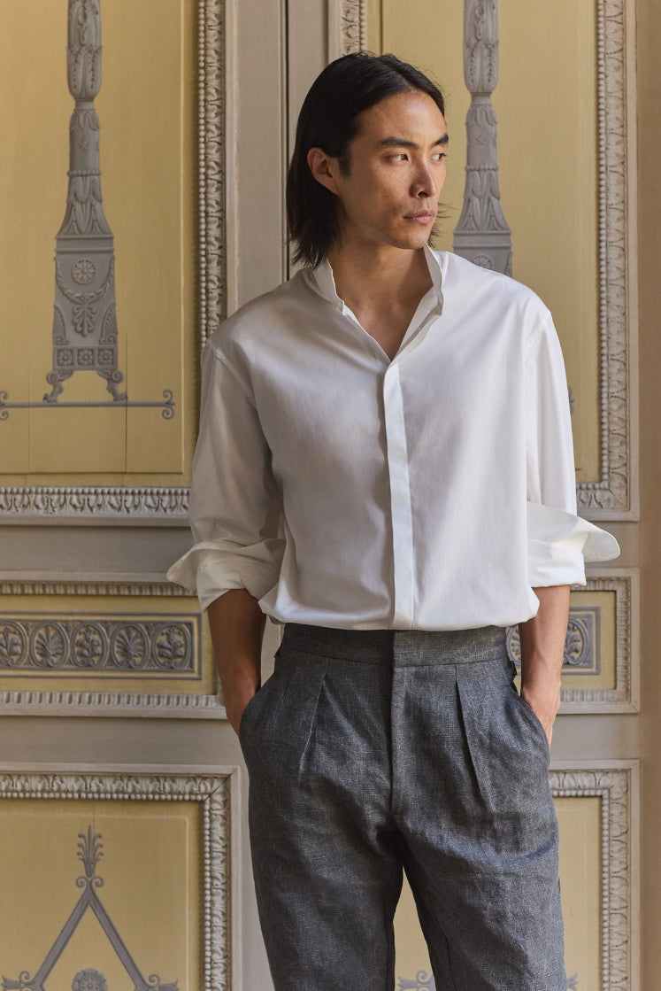 homme portant la chemise NUPTIALE en popeline de coton blanche à col haut, rentrée dans le pantalon HORIZON en lin plâtré gris