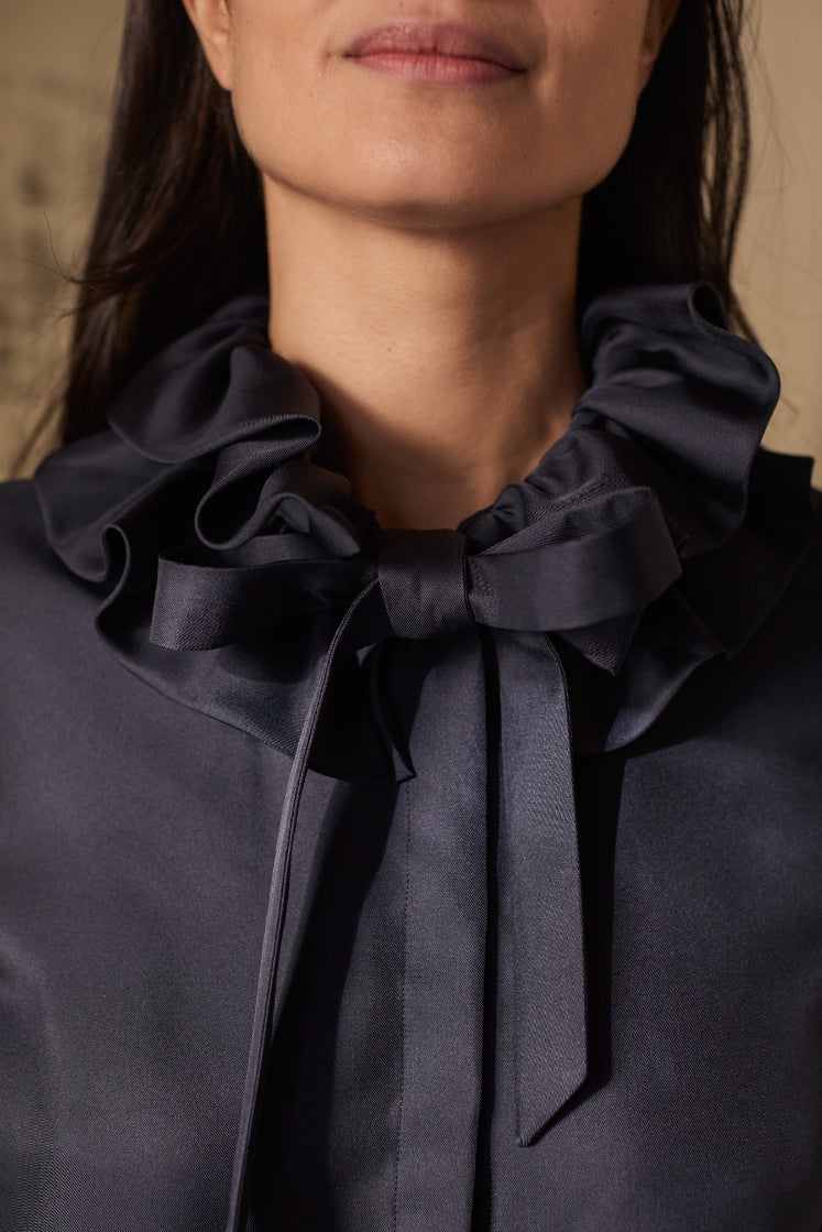 close-up sur les volants du col de la chemise PASTEL en soie navy, attaché en noeud papillon grâce aux liens pour resserrer.