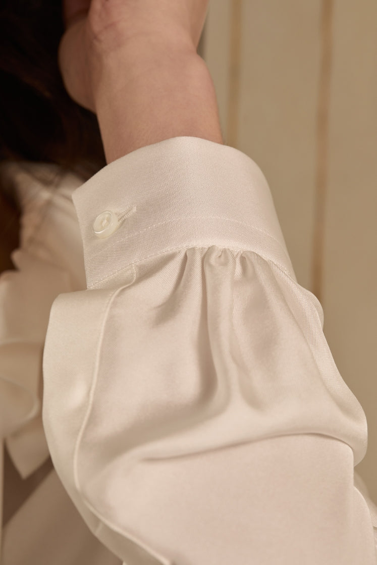 close-up sur le poignet de la chemise PASTEL en soie blanche.
