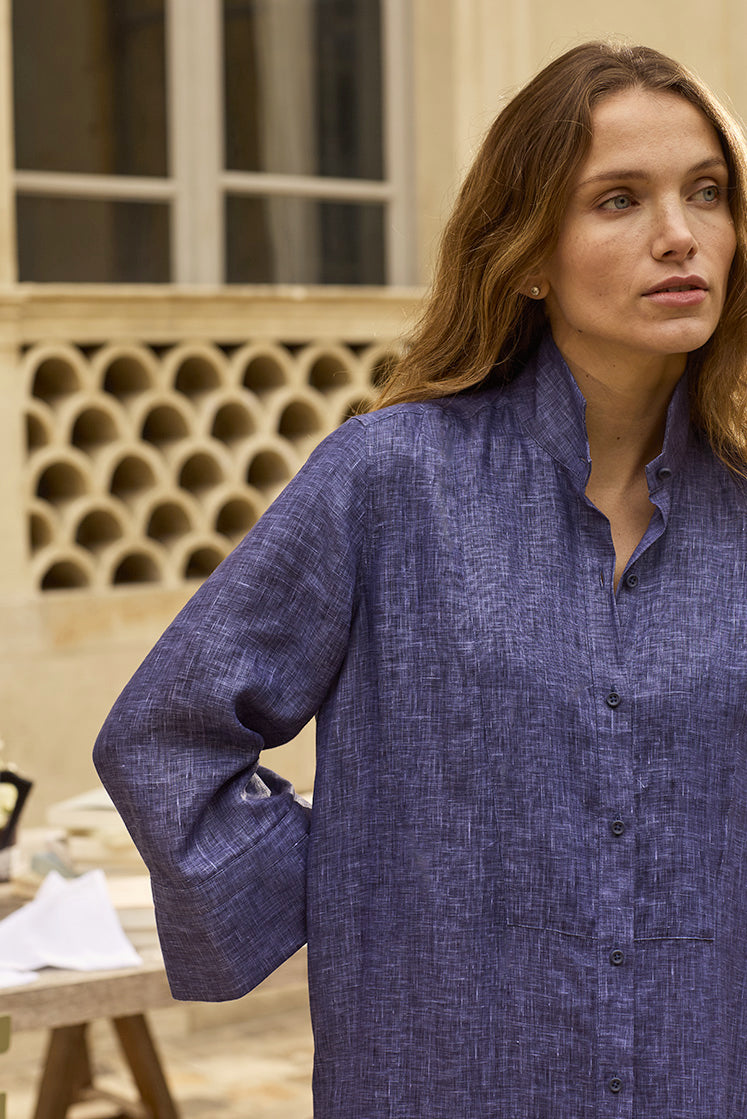 Femme portant une robe chemise bleu dans un jardin