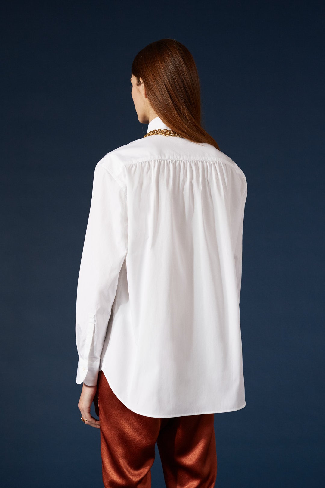 La chemise AMAZONE en blanc immaculé, pièce centrale de la collection Bourrienne, revisite élégamment le col ancien et présente des fronces distinctives à l'arrière, ajoutant une touche de raffinement.