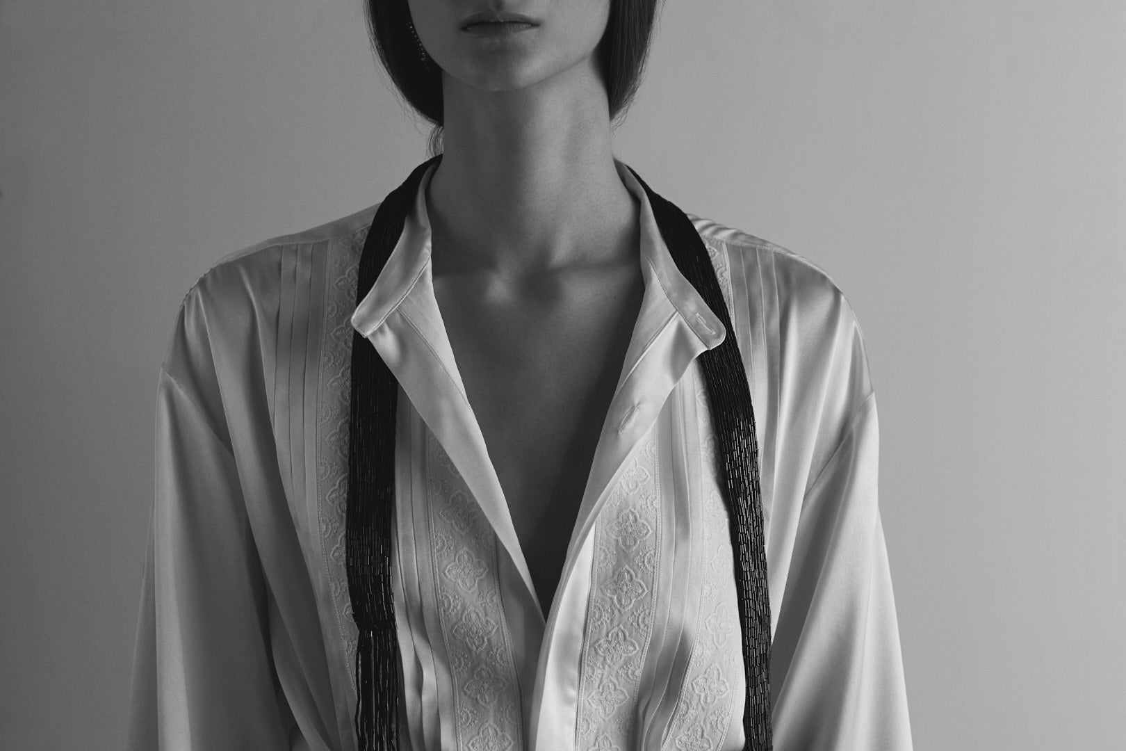 La chemise BALLET incarne le savoir-faire Bourrienne. Cette pièce à coupe romantique, façonnée dans de la soie tissée en Italie, est ornée de galons brodés et de plis.