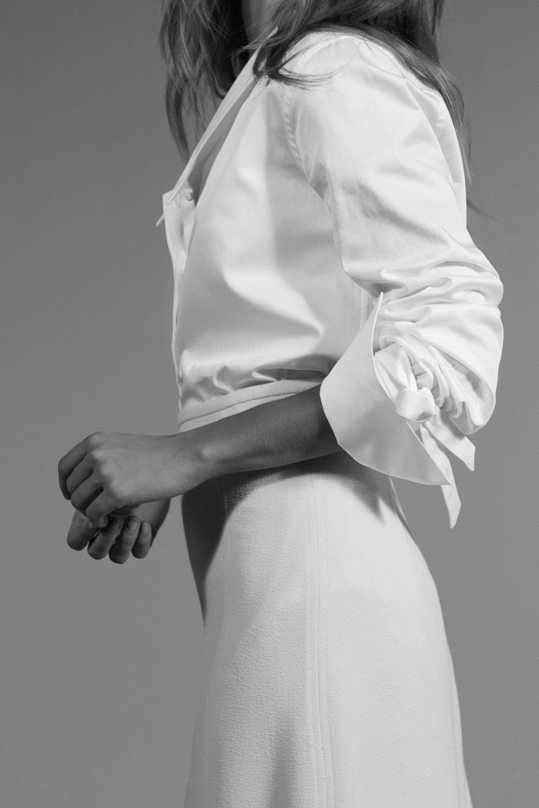 Plan de profil d'une femme portant la chemise DIVA, mettant en avant les poignets noués.