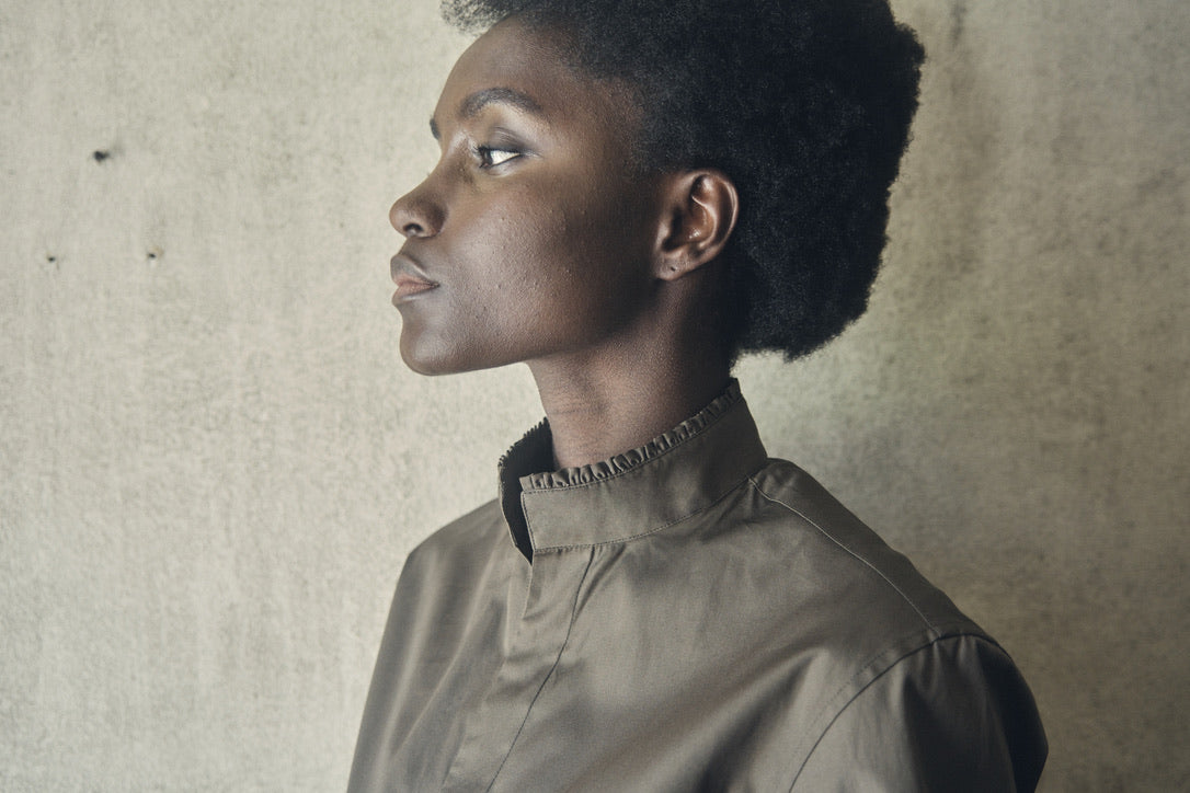 Close-up sur le col fermé de la chemise BOUDOIR Kaki et son col ancien orné de petits volants, vu de profil.