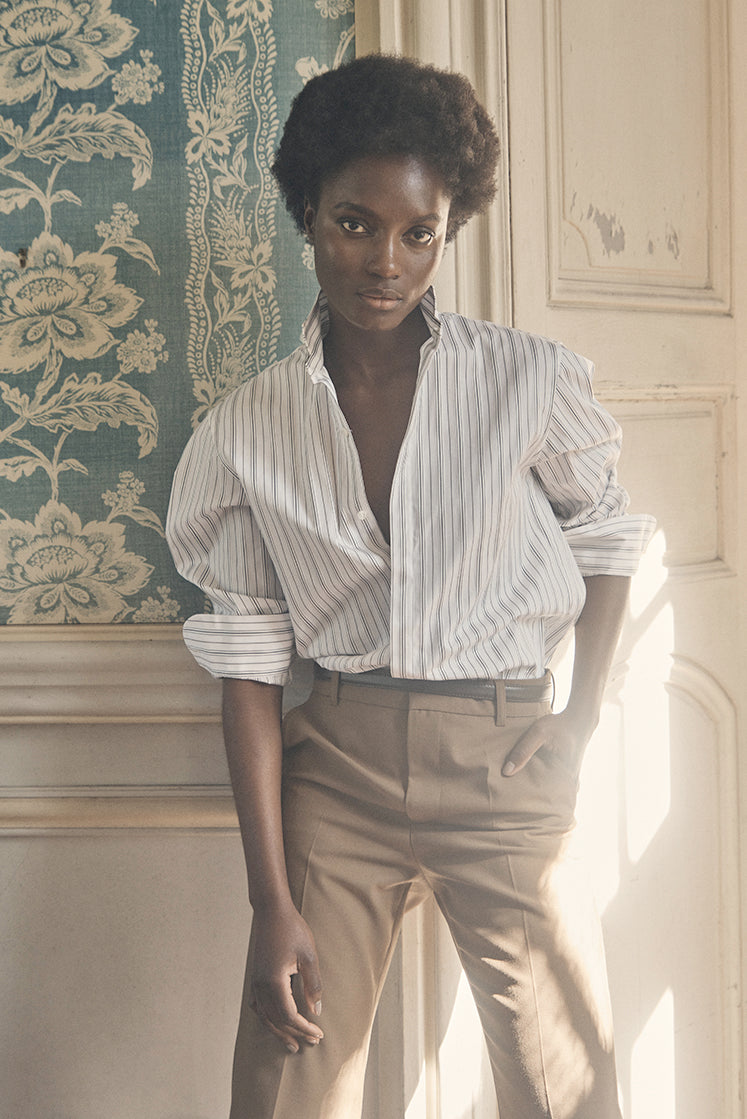 Chemise AMAZONE Rayée Kaki portée par une mannequin de face, adossée contre un mur.