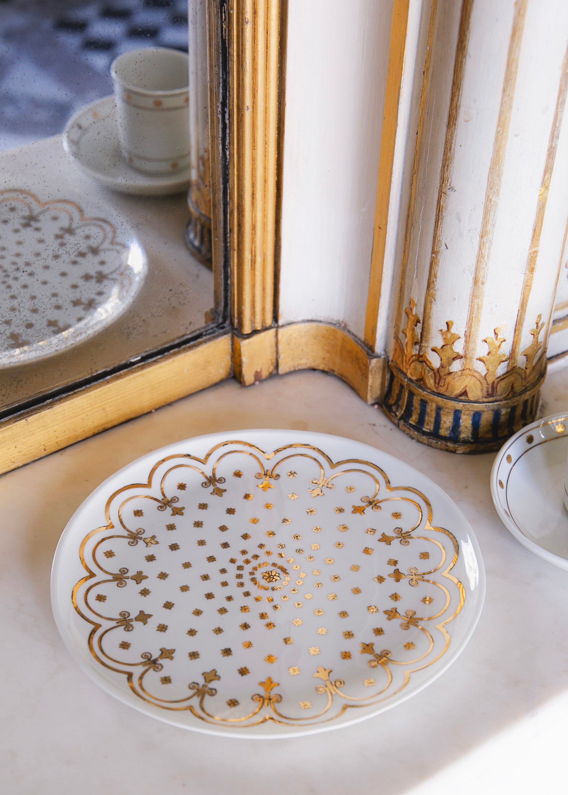 Assiette en porcelaine avec un motif décoratif doré qui reprend les ornements de l'Hôtel de Bourrienne