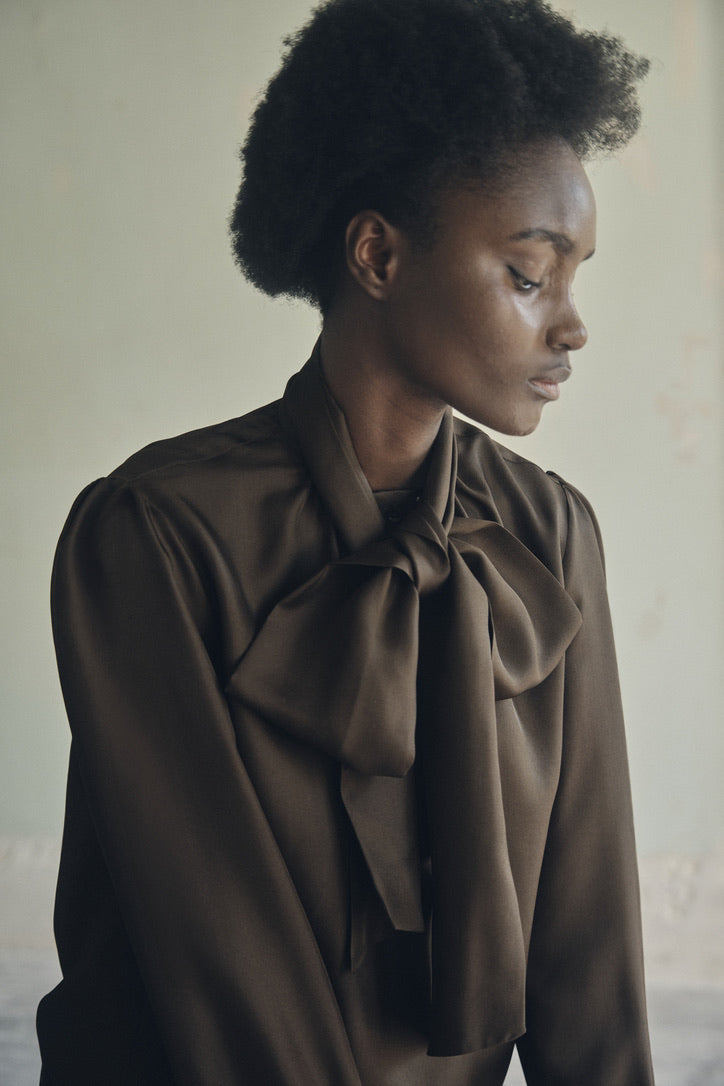 Close-up sur la chemise COMTESSE Soie Kaki avec un grand noeud au col.