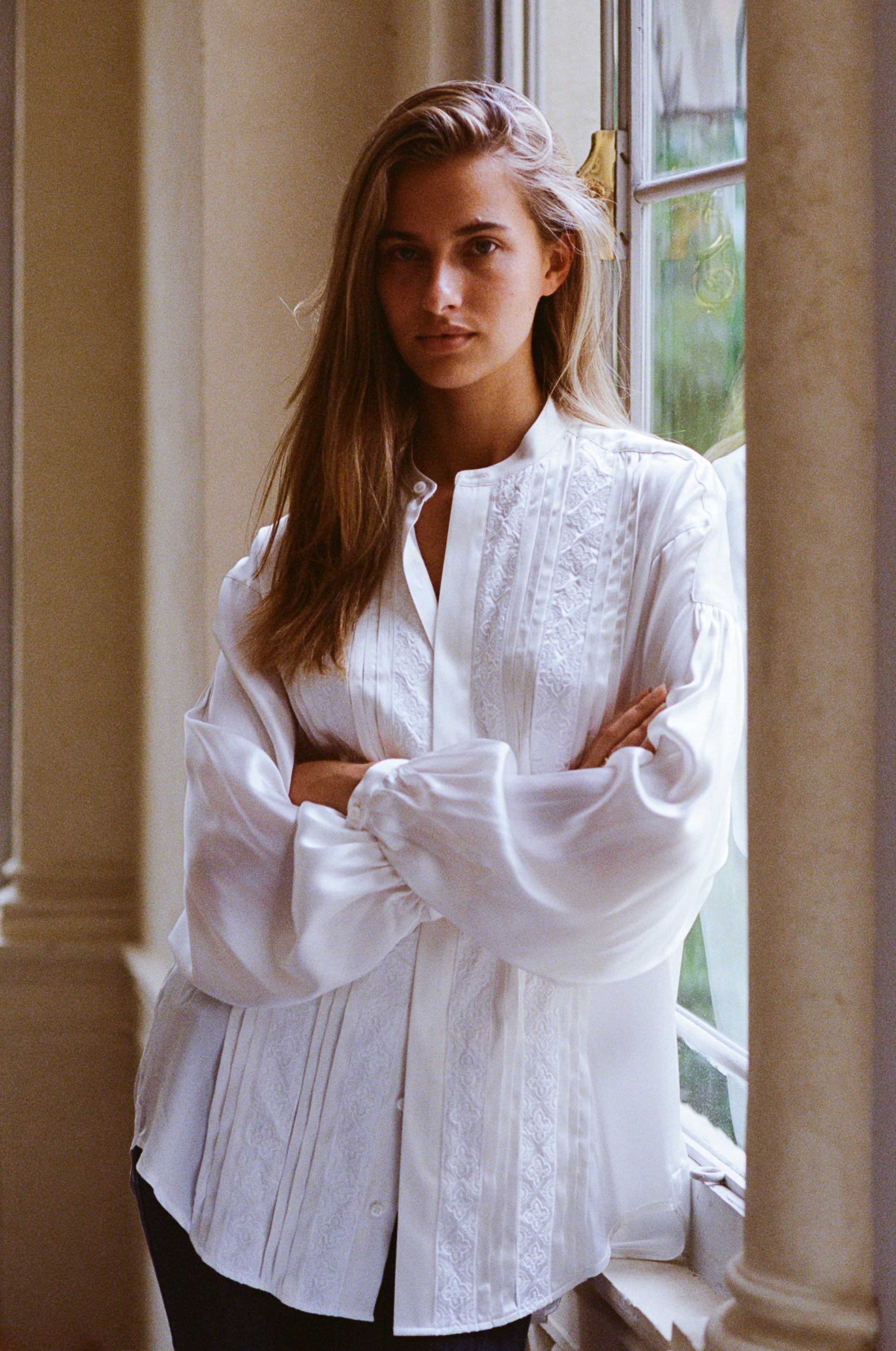 La chemise BALLET incarne le savoir-faire Bourrienne. Cette pièce à coupe romantique, façonnée dans de la soie tissée en Italie, est ornée de galons brodés et de plis.