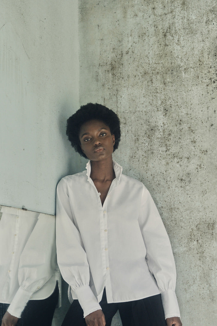 Plan américain de la mannequin portant la chemise PRÉCIEUSE blanche.