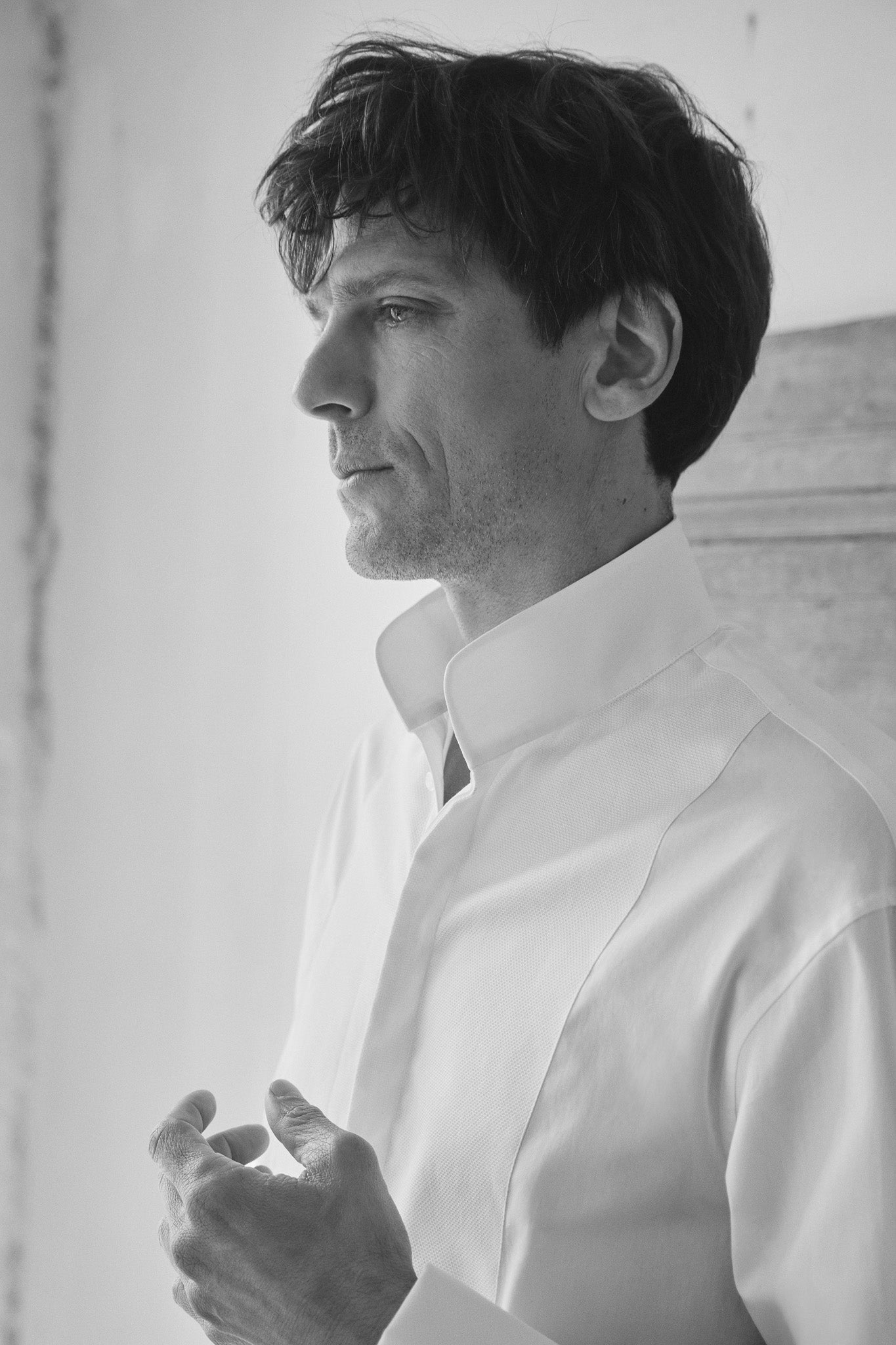 Plan buste d'un mannequin homme portant la chemise blanch MIRAGE, avec un col haut et un plastron.