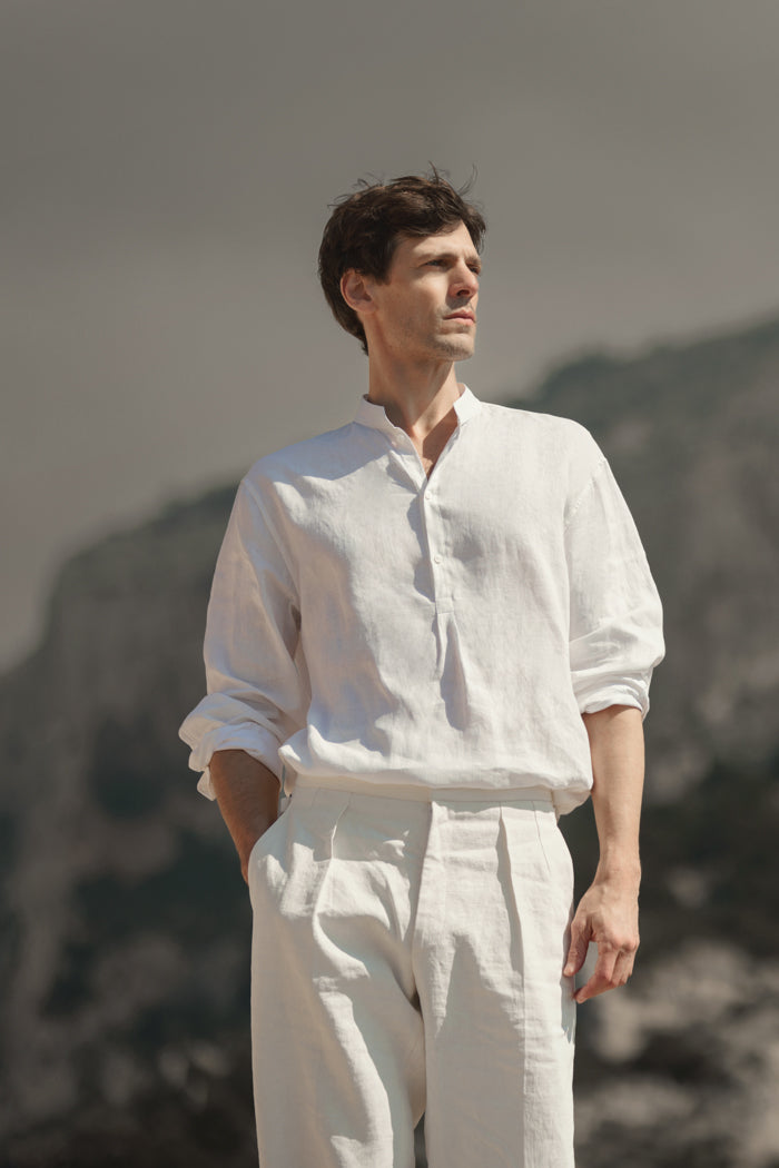 Chemise Homme Blanche en lin de Belgique, confectionnée en Europe, col officier biseauté et fronces dans le dos. Vue de face sur un pantalon en lin signé Bourrienne Paris X