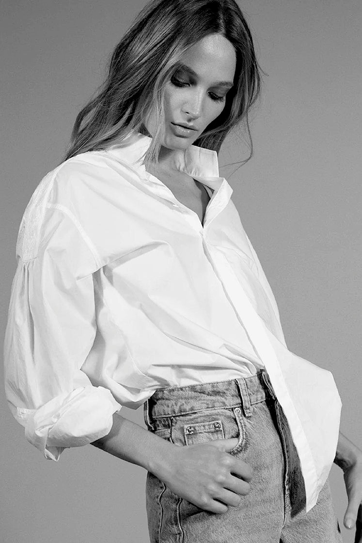 Femme portant la chemise blanche POETESSE par Bourrienne Paris X, avec un col haut et des galons brodés sur les épaules, photographie en noir et blanc.